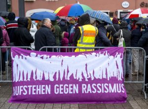 Absperrung mit Banner "Aufstehen gegen Rassismus" mit vielen Demonstranten